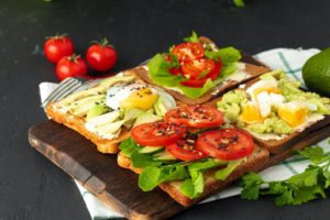 Fried toasts with avocado and egg, and with cream cheese and tomatoes